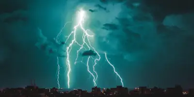 Un fulger cade deasupra unui oras slab vizibil