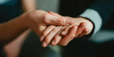 Palma unui om o sustine pe cea a altui om, vazute de aproape