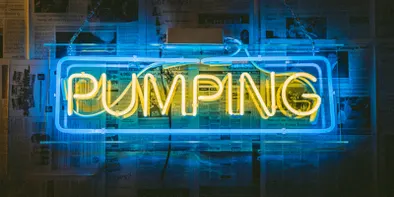 Cuvantul pumping scris cu neoane albastre si galbene aprinse pe un perete