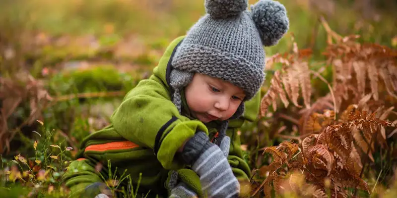 Un copil de gradinita in iarba, toamna
