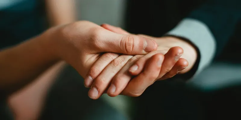 Palma unui om o sustine pe cea a altui om, vazute de aproape