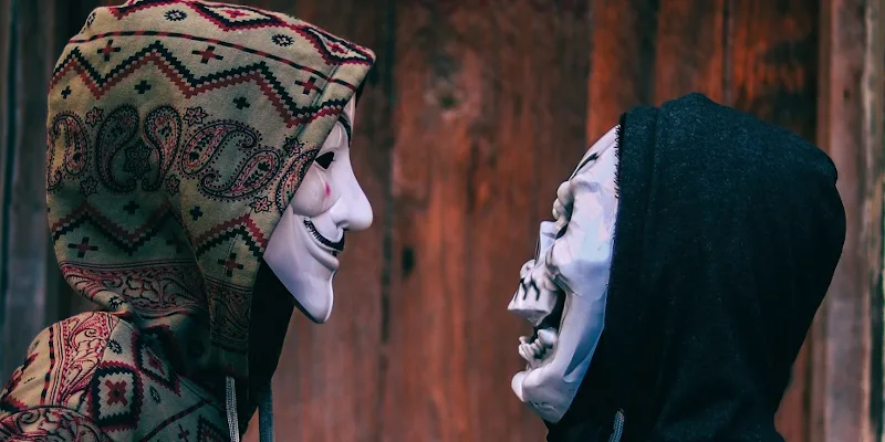 Doi oameni cu masti albe pe fata se uita unul la altul